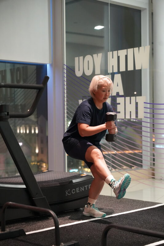 A coached group strength class for women, working through squats and presses